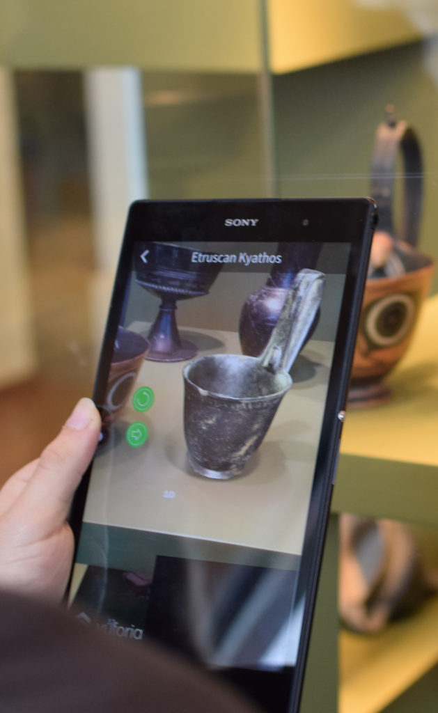 AR on a tablet which recognises artefact shapes and overlays them with a 3D model of the object, allowing the user to interact with the object.